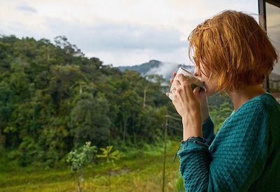 woman reflecting over cup of coffee